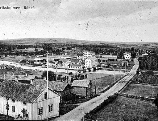 Bild_nr_0001_exposure.jpg - Foto av Råneå från tiden då föreningen bildades 1923I förgrunden Tingshuset och i v. kanten den gamla krogen på Klapphällan. På andra sidan älven syns skäret och uppströms Lundins garveri, Kraftverket och Kvarnen med dammbron samt kvarnstugan intill vägen. Uppe på backen Lundins skoaffär med fabriken till vänster.